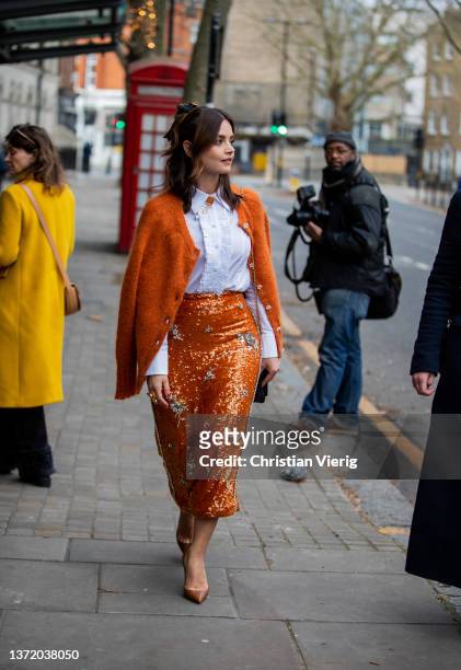 Actress Jenna Coleman is seen wearing orange skirt, cardigan, white blouse, black bag, heels outside Erdem during London Fashion Week February 2022...