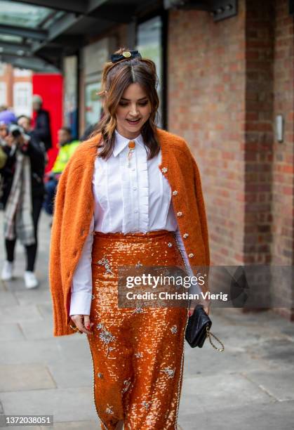 Actress Jenna Coleman is seen wearing orange skirt, cardigan, white blouse, black bag outside Erdem during London Fashion Week February 2022 on...