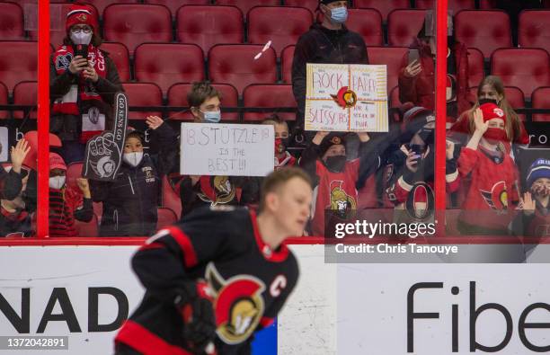 Fans hold up signs during warmups prior to a game between New York Rangers and Ottawa Senators at Canadian Tire Centre on February 20, 2022 Ottawa,...