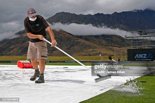 Ground staff wipe water off from the covers during game four in the One Day International series between the New Zealand White Ferns and India at...