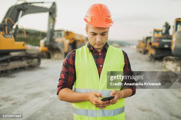 male engineer working in construction site. - male cellphone stock-fotos und bilder