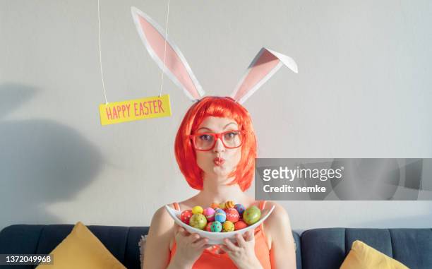 woman wearing bunny ears and holding easter eggs - rabbit costume stock pictures, royalty-free photos & images