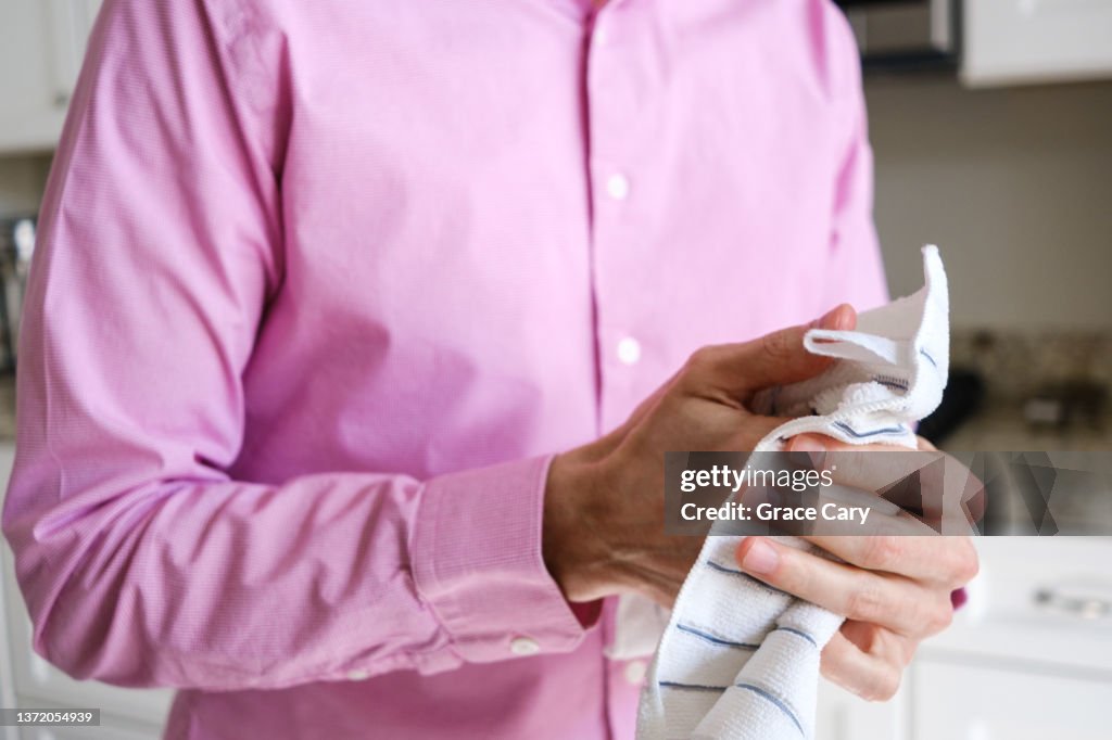 Man Dries His Hands With Kitchen Towel