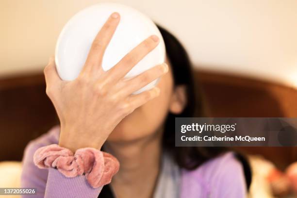 mixed-race teenage girl holds a white bowl up to her mouth while snacking - hair elastic stock pictures, royalty-free photos & images