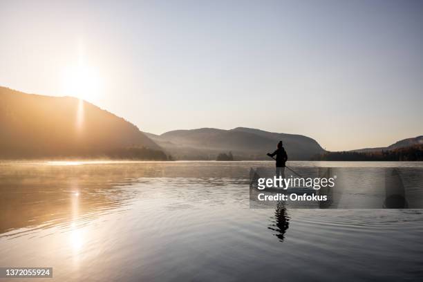 woman paddleboarding on the lake in autumn, mont tremblant national park, quebec, canada - quebec landscape stock pictures, royalty-free photos & images