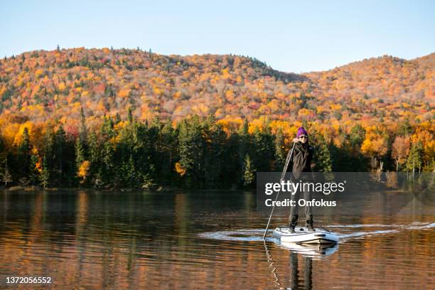 woman paddleboarding on the lake in autumn, mont tremblant national park, quebec, canada - quebec landscape stock pictures, royalty-free photos & images
