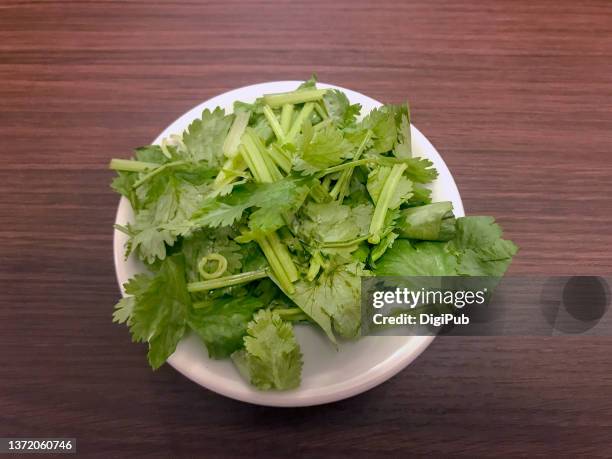 coriander in saucer on table - コリアンダー ストックフォトと画像