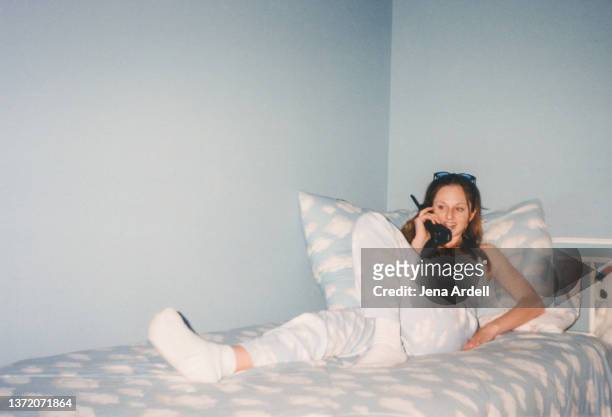 vintage teenage girl talking on telephone in 1990s bedroom cloud print y2k fashion 2000s - jaar 2000 stijl stockfoto's en -beelden