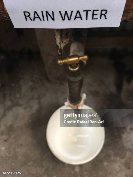 rain water sign on an old farm faucet and bucket - metal bucket stock pictures, royalty-free photos & images