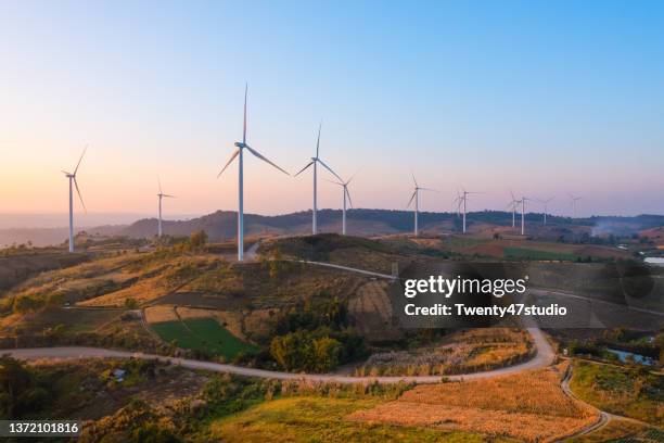 aerial view of wind turbine farm on the hill produces electricity for clean energy - suministro de energía fotografías e imágenes de stock