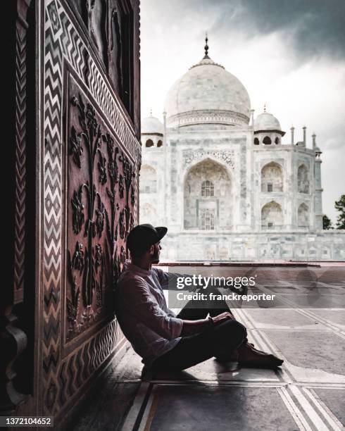 tourist sitting at the entrance of taj mahal in agra - islam temple stock pictures, royalty-free photos & images