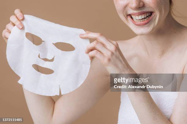 happy woman with sheet cosmetic face mask. the concept of spa procedures and skin rejuvenation. - cloth mask 個照片及圖片檔