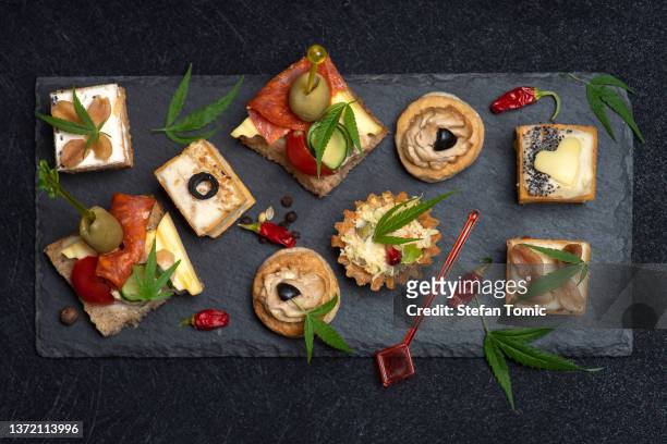 canapes with different topping and marijuana leaves - canapé 個照片及圖片檔