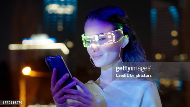 young woman using smart phone in the city - computador utilizável como acessório imagens e fotografias de stock