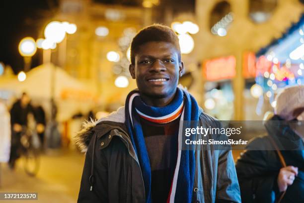 portrait of young african american man standing on street - zagreb night stock pictures, royalty-free photos & images