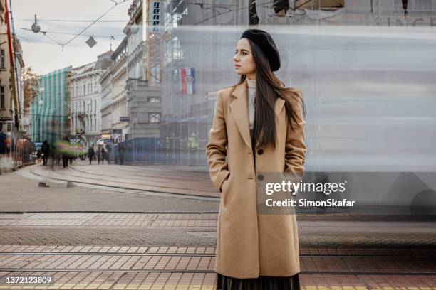 junge frau steht mit händen in taschen auf der straße - zagreb stock-fotos und bilder