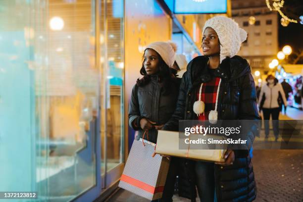 two sisters with christmas gifts window shopping - croatia girls stock pictures, royalty-free photos & images