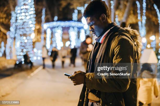 african american man using mobile phone in the park - zagreb night stock pictures, royalty-free photos & images