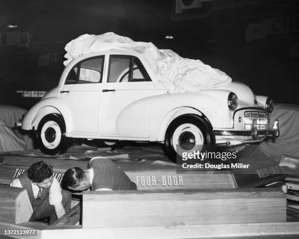 Workmen finish constructing the stand for the new Morris Minor 4-door saloon car at the 35th British International Motor Show on 16th October 1950 at...
