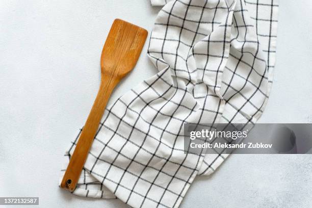 a new clean wooden spatula, a kitchen towel and a salt shaker on the dining table. the concept of cooking in a restaurant and cafe, at home in the kitchen. cook it yourself, taking courses on the ability to cook delicious and beautiful food. copy space. - spatula stock pictures, royalty-free photos & images