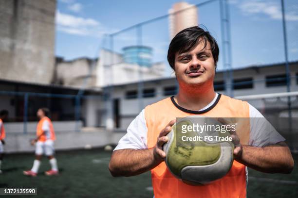portrait of a young male soccer player with special needs in a sports court - down syndrome bildbanksfoton och bilder