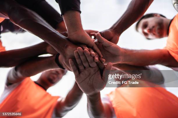 players stacking hands together on the soccer field - team hands in huddle stock pictures, royalty-free photos & images