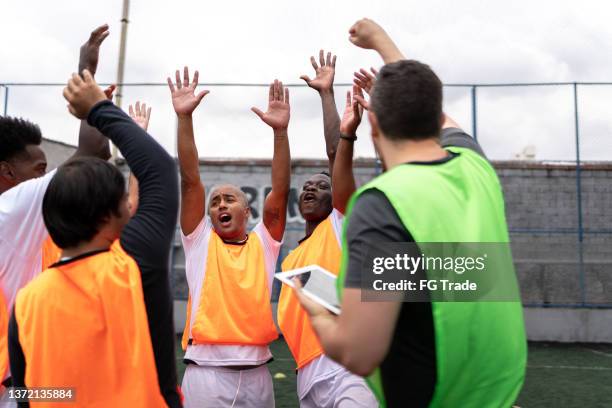 entrenador y equipo celebrando en el campo de fútbol - amateur football fotografías e imágenes de stock