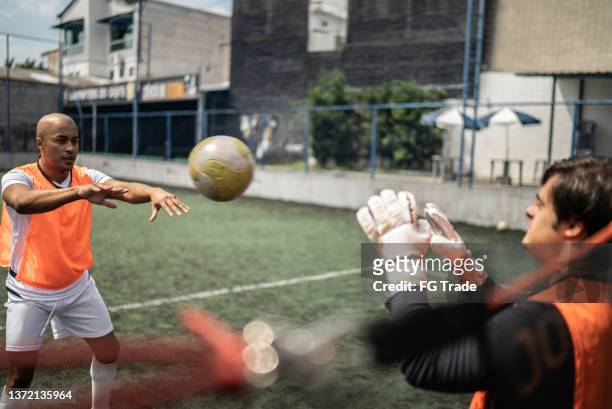 disabled goalkeeper and friend training on the soccer field - verdediger voetballer stockfoto's en -beelden