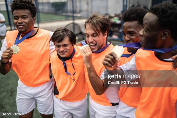 players celebrating winning a medal on the soccer field - including a person with special needs - sportsperson medal stock pictures, royalty-free photos & images
