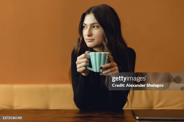 people with hot beverage. concept with copy space. portrait of young girl who looks left. photo indoor with cup of drink on yellow background. - similar stock pictures, royalty-free photos & images