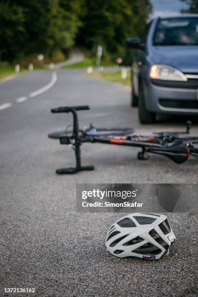 fahrradausrüstung vor dem auto liegend - bike accident stock-fotos und bilder