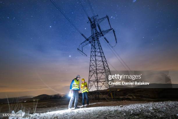 ingenieros de alto voltaje que trabajan de noche en el campo. trabajo en equipo. - electricidad fotografías e imágenes de stock