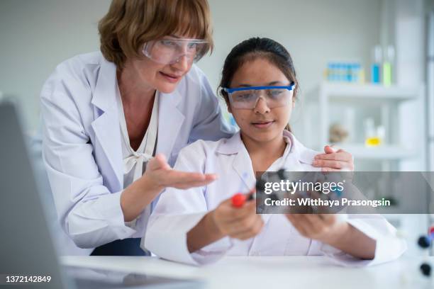 high school girl holding a glucose molecular model in the chemistry lab - science lab school stock-fotos und bilder