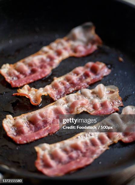 bacon slices grilled in a pan high quality photo - bacon strip stock pictures, royalty-free photos & images