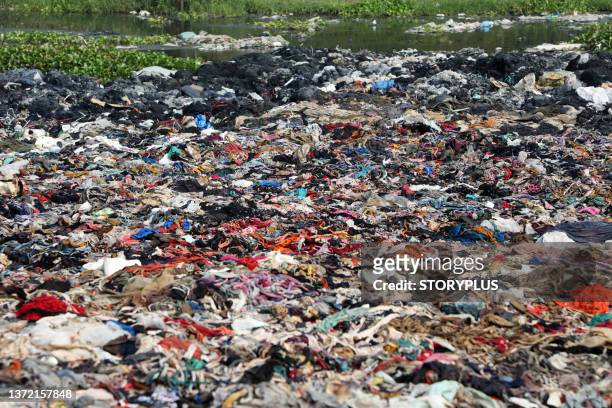 garment factory waste dump contributes to environmental issues in bangladesh - vestido fotografías e imágenes de stock