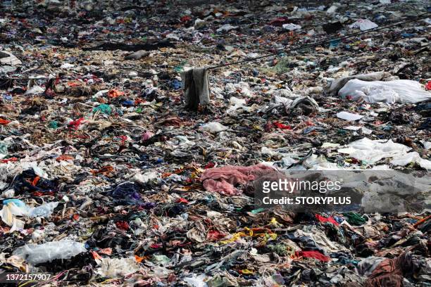 garment factory waste dump contributes to environmental issues in bangladesh - clothes landfill bildbanksfoton och bilder