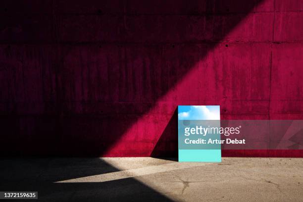 conceptual picture of a mirror reflecting sky in minimal architecture with red wall. - sadness background stock pictures, royalty-free photos & images
