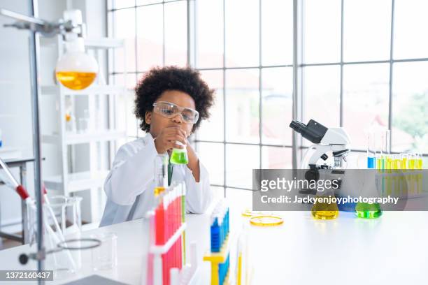 a boy doing experiments in the laboratory. explosion in the laboratory. science and education. - scientist and explosion stock pictures, royalty-free photos & images