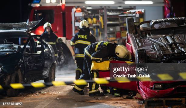 車の事故現場で消防士 - 自動車事故 ストックフォトと画像