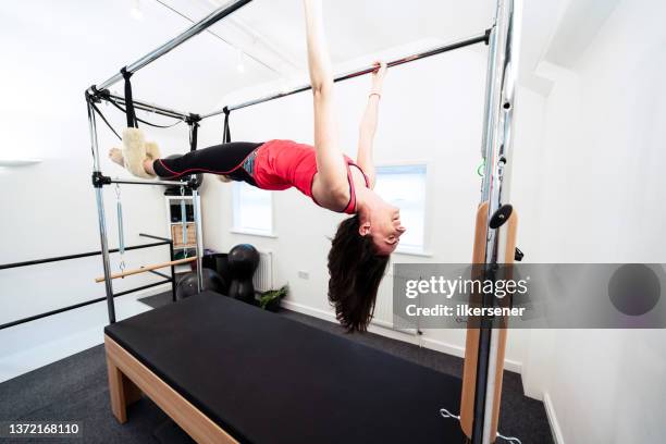 woman doing pilates in studio - reformer stock pictures, royalty-free photos & images