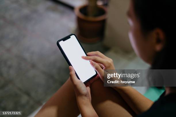 asian woman using smartphone at home - finger dialing touch tone telephone stock pictures, royalty-free photos & images