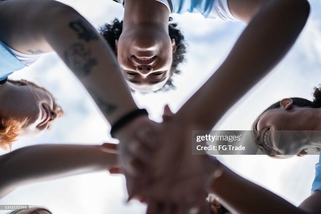 Female soccer team huddling before training or match