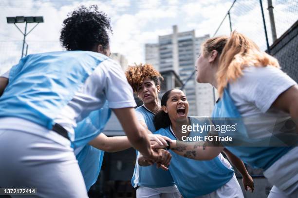 female soccer team huddling and celebrating before training or match - sports training bildbanksfoton och bilder