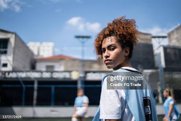porträt einer jungen fußballspielerin auf einem sportplatz - angriffs trainer football stock-fotos und bilder