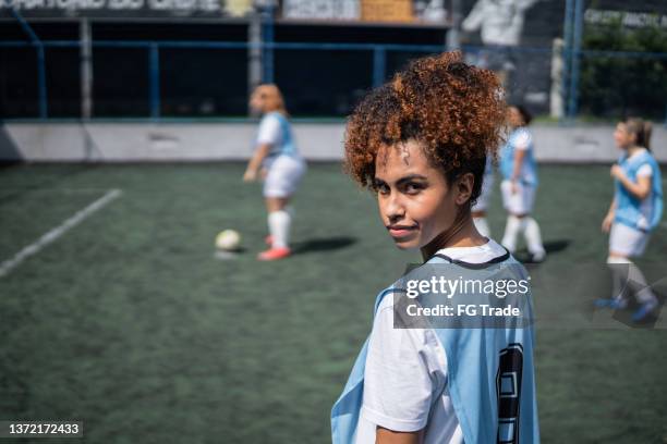 retrato de una joven jugadora de fútbol en una cancha deportiva - fútbol femenino fotografías e imágenes de stock