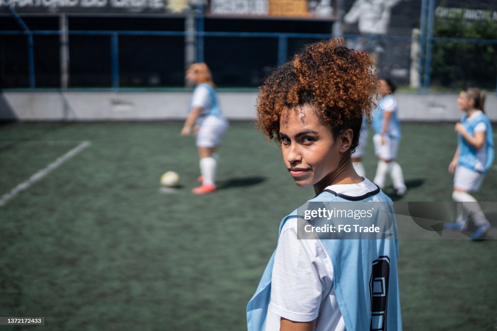 Portrait of a young female soccer player in a sports court