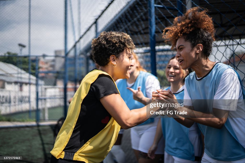Calciatrici che si stringono la mano prima della partita