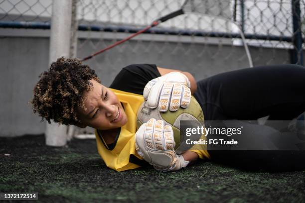 female goalkeeper catching a soccer ball - goalkeeper stock pictures, royalty-free photos & images