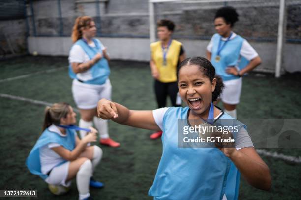 retrato de una jugadora de fútbol celebrando ganar una medalla - the championship competición de fútbol fotografías e imágenes de stock