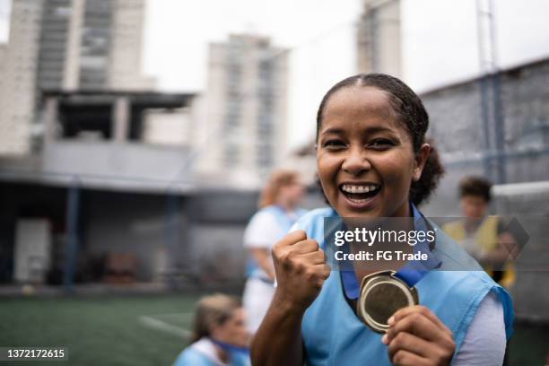 portrait of a female soccer player celebrating winning a medal - football team trophy stock pictures, royalty-free photos & images